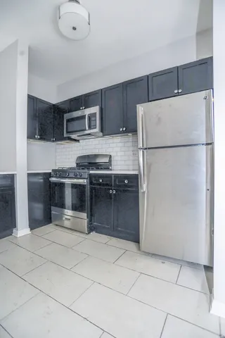 a kitchen with stainless steel appliances granite countertop a refrigerator and a stove