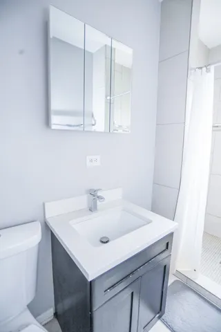 a bathroom with a sink a toilet and a mirror