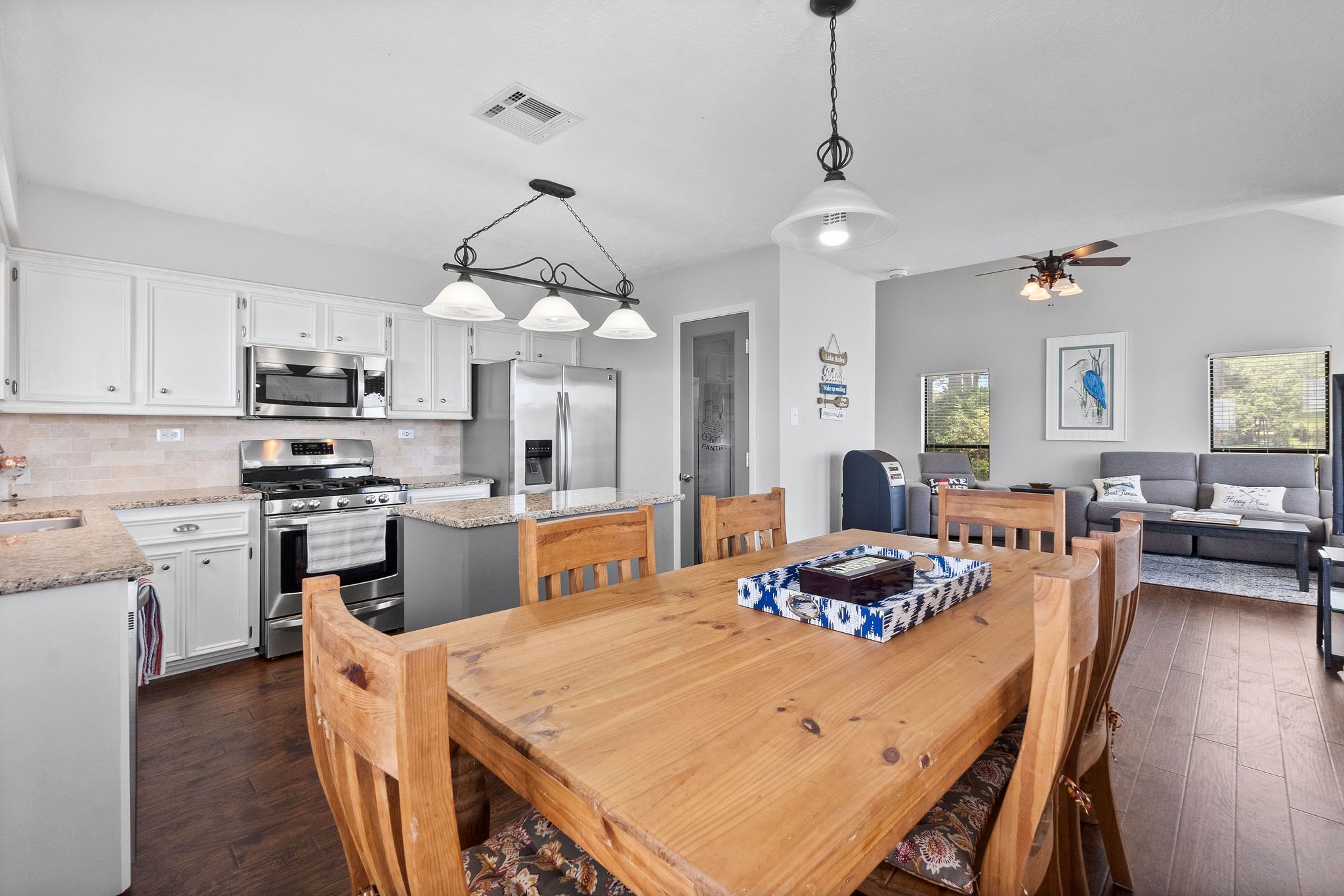 154 Point Drive Onalaska, TX 77360 - Photo 14 of 46 a kitchen with stainless steel appliances granite countertop a stove a sink dishwasher a dining table and chairs with wooden floor