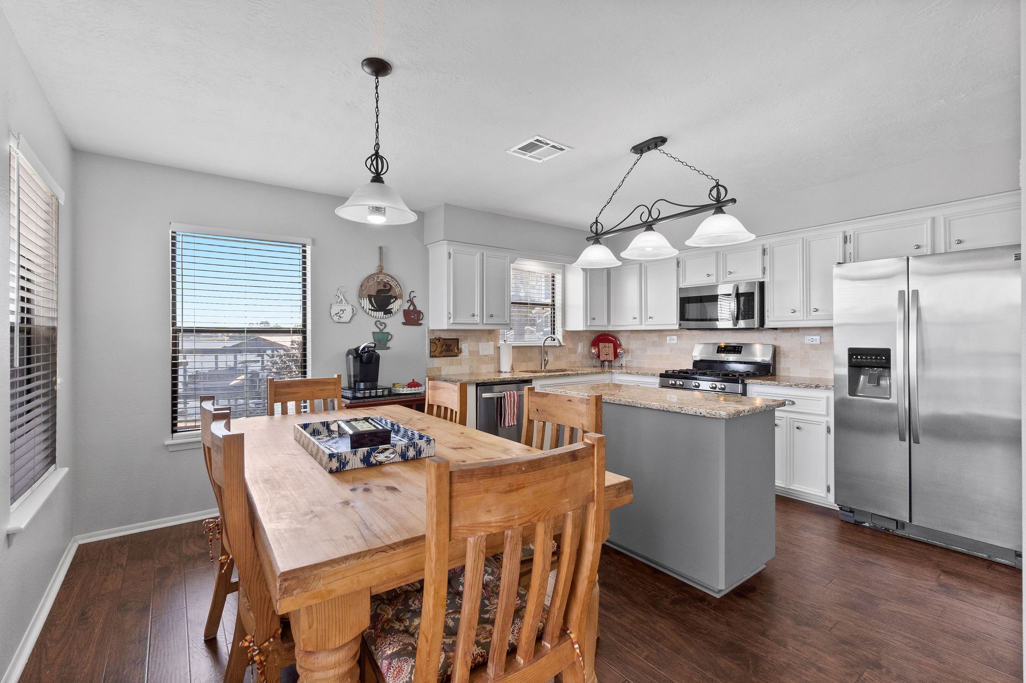154 Point Drive Onalaska, TX 77360 - Photo 15 of 46 a kitchen with stainless steel appliances granite countertop a dining table chairs refrigerator and wooden floor