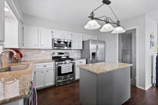 a kitchen with a center island and stainless steel appliances