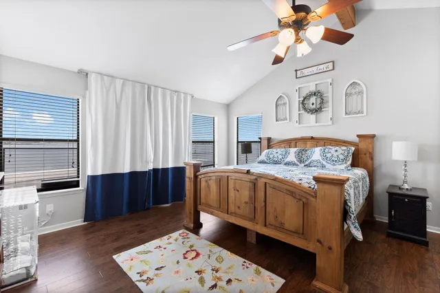 a spacious bedroom with a bed and wooden floor