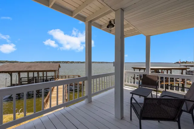 a view of a balcony with chairs wooden floor and fence