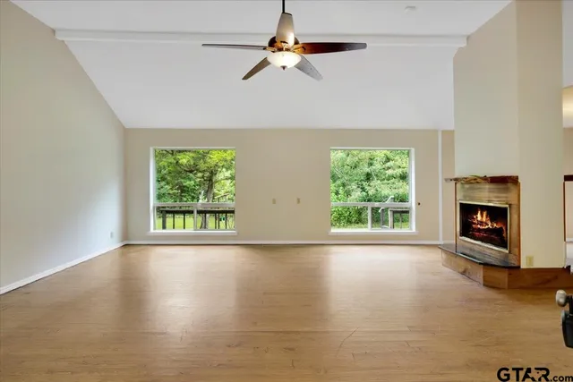 a view of an empty room with window and fire place