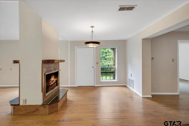 a view of a livingroom with a fireplace wooden floor and window