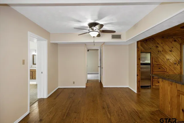 a view of empty room with wooden floor