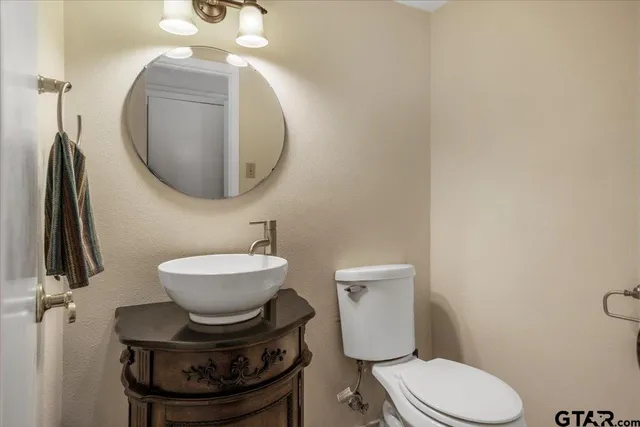 a bathroom with a toilet a sink and mirror
