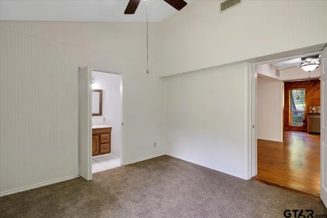 an empty room with closet and windows