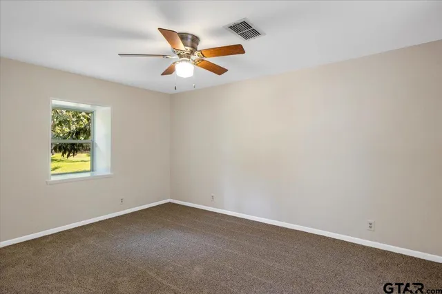 an empty room with closet and fan