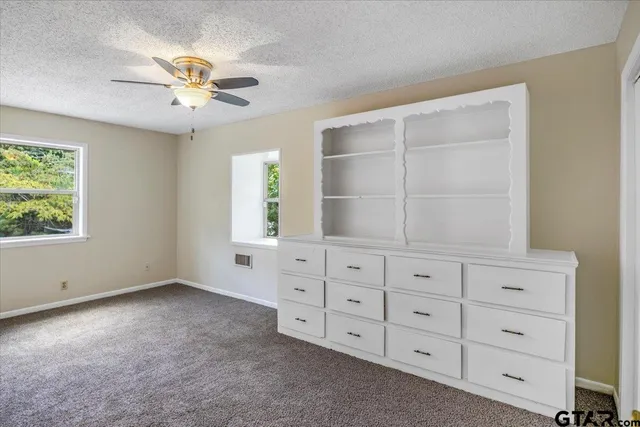a view of an empty room with window and cabinet
