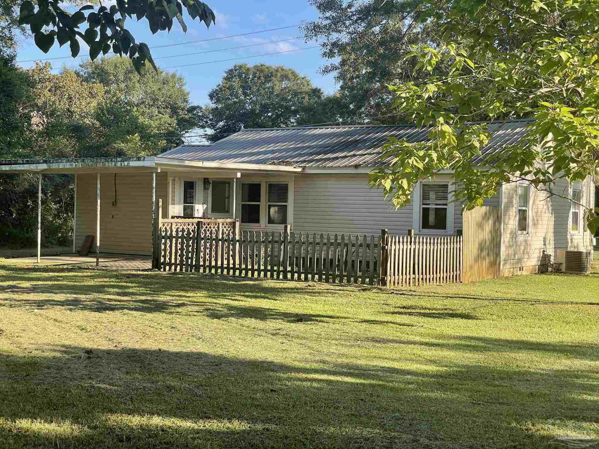 3824 Williams Avenue Jay, FL 32565 - Photo 10 of 11 a view of a house in a yard with plants and trees