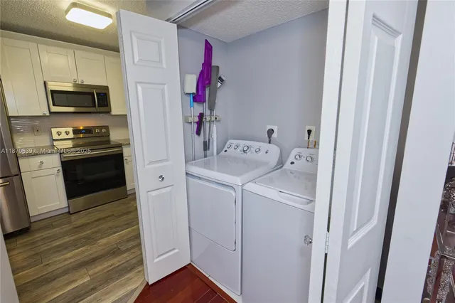 a view of a kitchen with fridge and wooden floor
