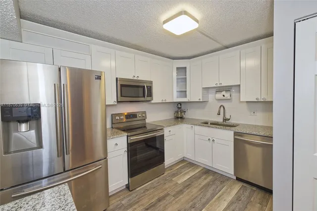 a kitchen with cabinets stainless steel appliances a sink and a counter top space