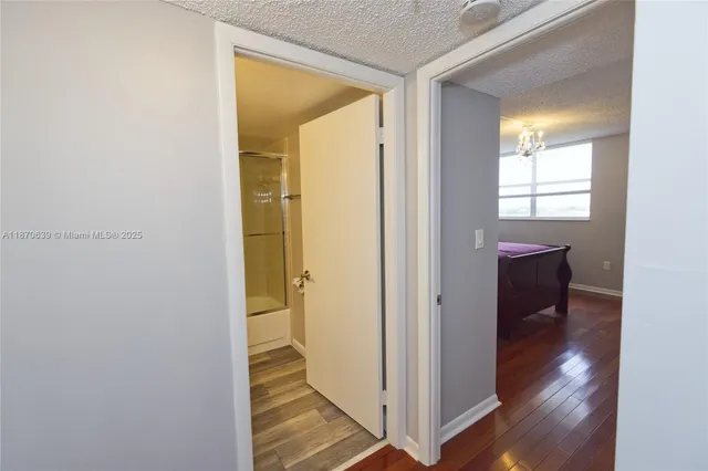 a view of a hallway with wooden floor and closet