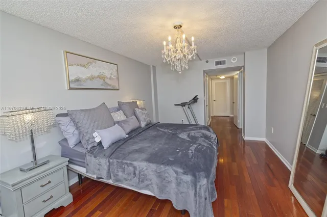 a bedroom with bed and wooden floor