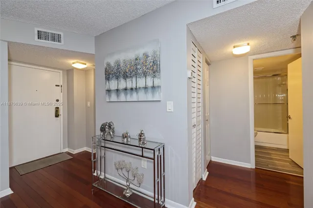 a view of a hallway with wooden floor and closet