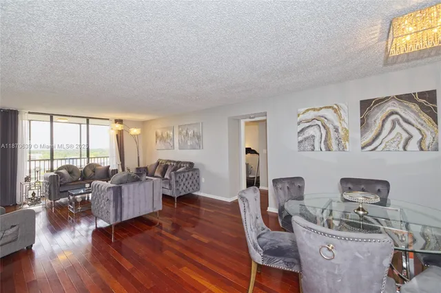 a living room with furniture large window and wooden floor