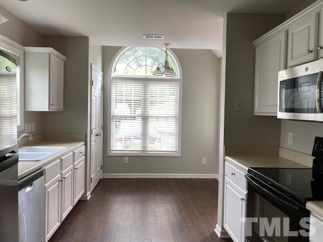 209 Harris Road Wake Forest, NC 27587 - Photo 2 of 9 a kitchen with stainless steel appliances a stove cabinets and wooden floor