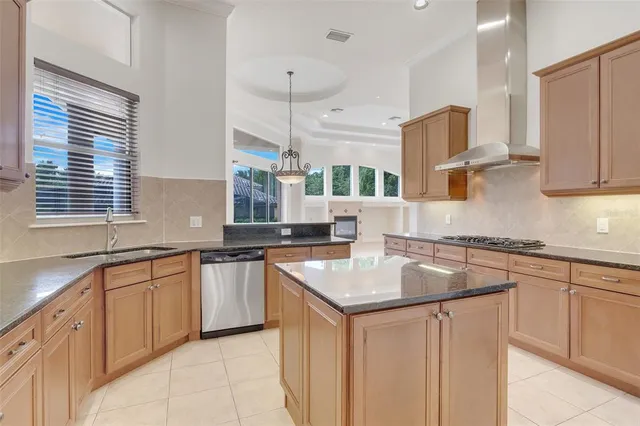 a kitchen with stainless steel appliances granite countertop a refrigerator a sink and white cabinets