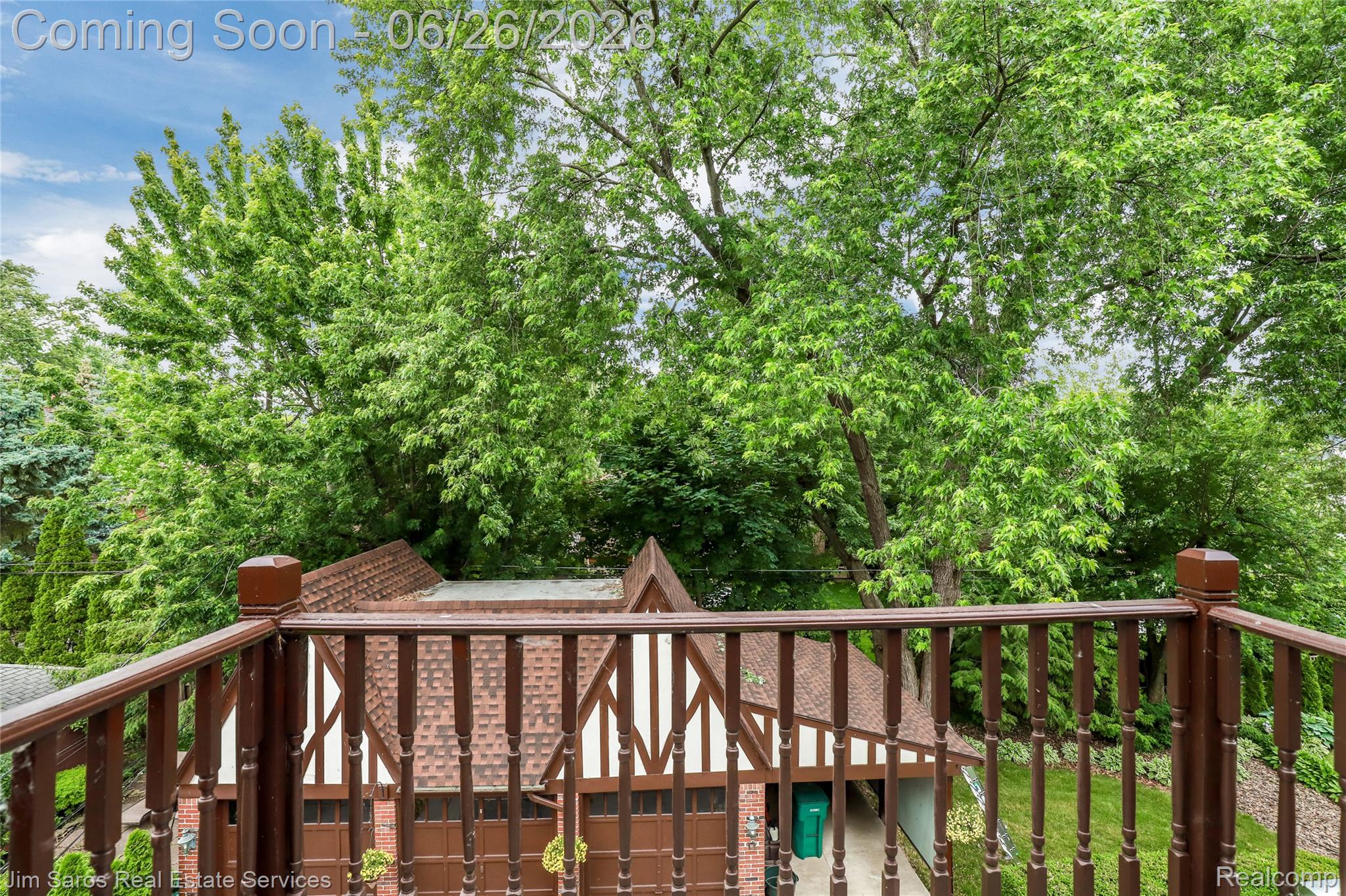 764 Harcourt Road Grosse Pointe, MI 48230 - Photo 35 of 42 Balcony with dark wood railing overlooking a Tudor-style garage with a brown shingle roof and white half-timbering details