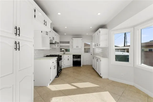 a large white kitchen with cabinets and stainless steel appliances