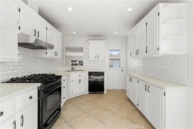 a kitchen with granite countertop a stove sink and cabinets