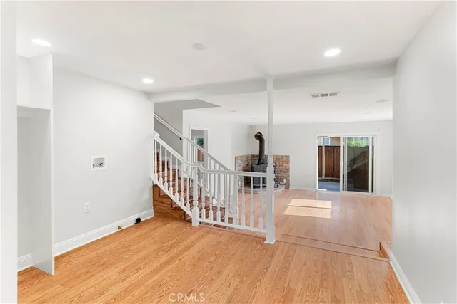 a view of a hallway with wooden floor and windows