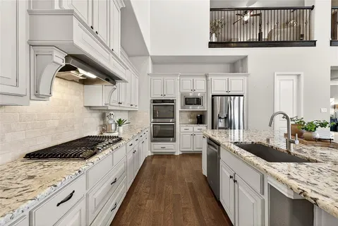 a kitchen with stainless steel appliances granite countertop a stove a sink and a refrigerator