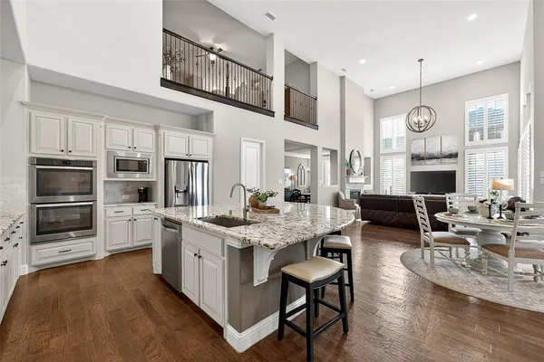 a large kitchen with cabinets table and chairs