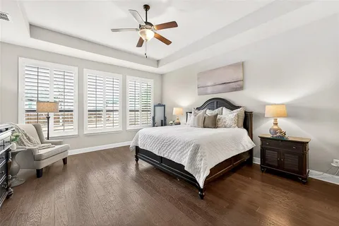 a spacious bedroom with a bed a couch and a large window