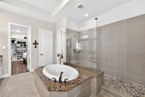 a bathroom with a granite countertop sink a toilet and shower