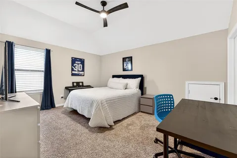 a spacious bedroom with a bed and a desk