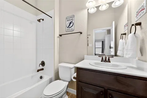 a bathroom with a sink a toilet a mirror and shower