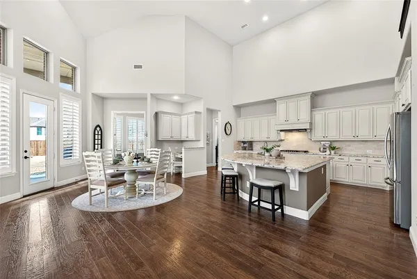a large kitchen with a table and chairs in it