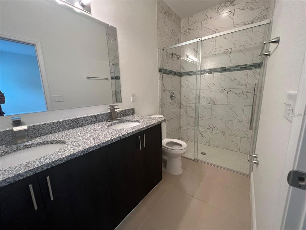 15087 Southwest 51st Terrace Ocala, FL 34473 - Photo 11 of 14 a bathroom with a granite countertop sink toilet and shower