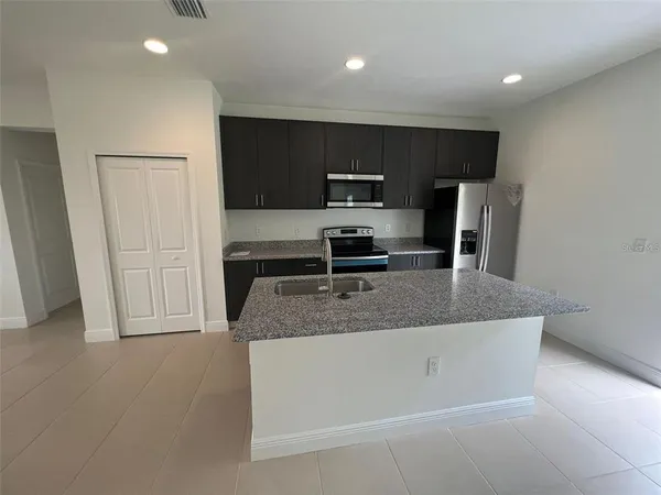 a kitchen with kitchen island a counter top space cabinets stainless steel appliances and a counter top space