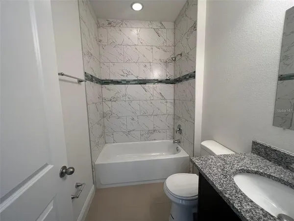 a bathroom with a granite countertop toilet sink and shower
