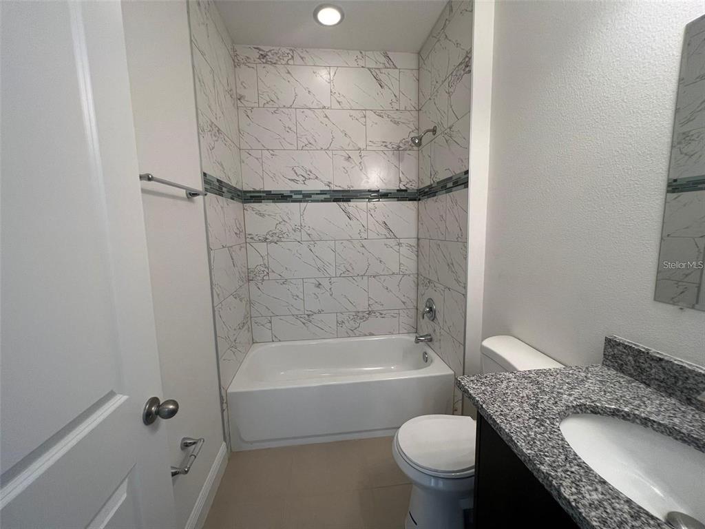 15087 Southwest 51st Terrace Ocala, FL 34473 - Photo 5 of 14 a bathroom with a granite countertop toilet sink and shower