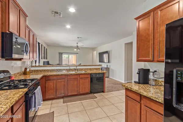 a kitchen with stainless steel appliances granite countertop a stove a sink and a microwave