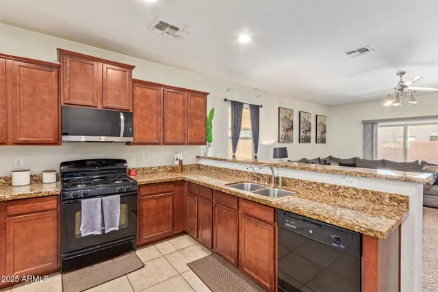 a kitchen with stainless steel appliances granite countertop a stove a sink dishwasher and a microwave oven with cabinets