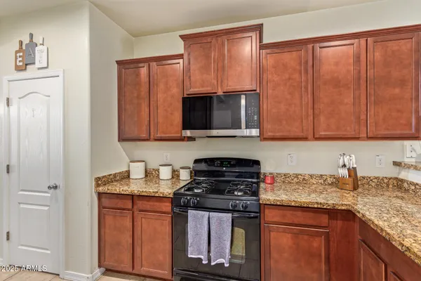 a kitchen with stainless steel appliances granite countertop a stove a sink and a microwave