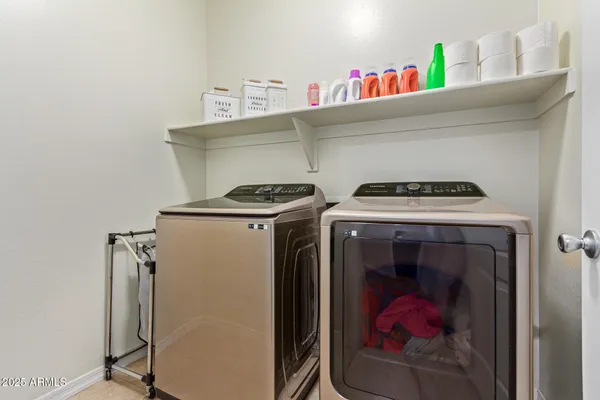 a utility room with dryer washer and empty racks