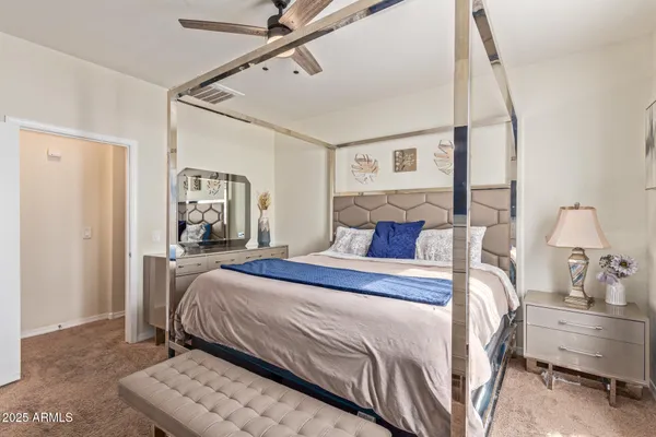 a bedroom with a bed and a mirror on the dresser