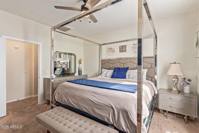 a bedroom with a bed and a mirror on the dresser