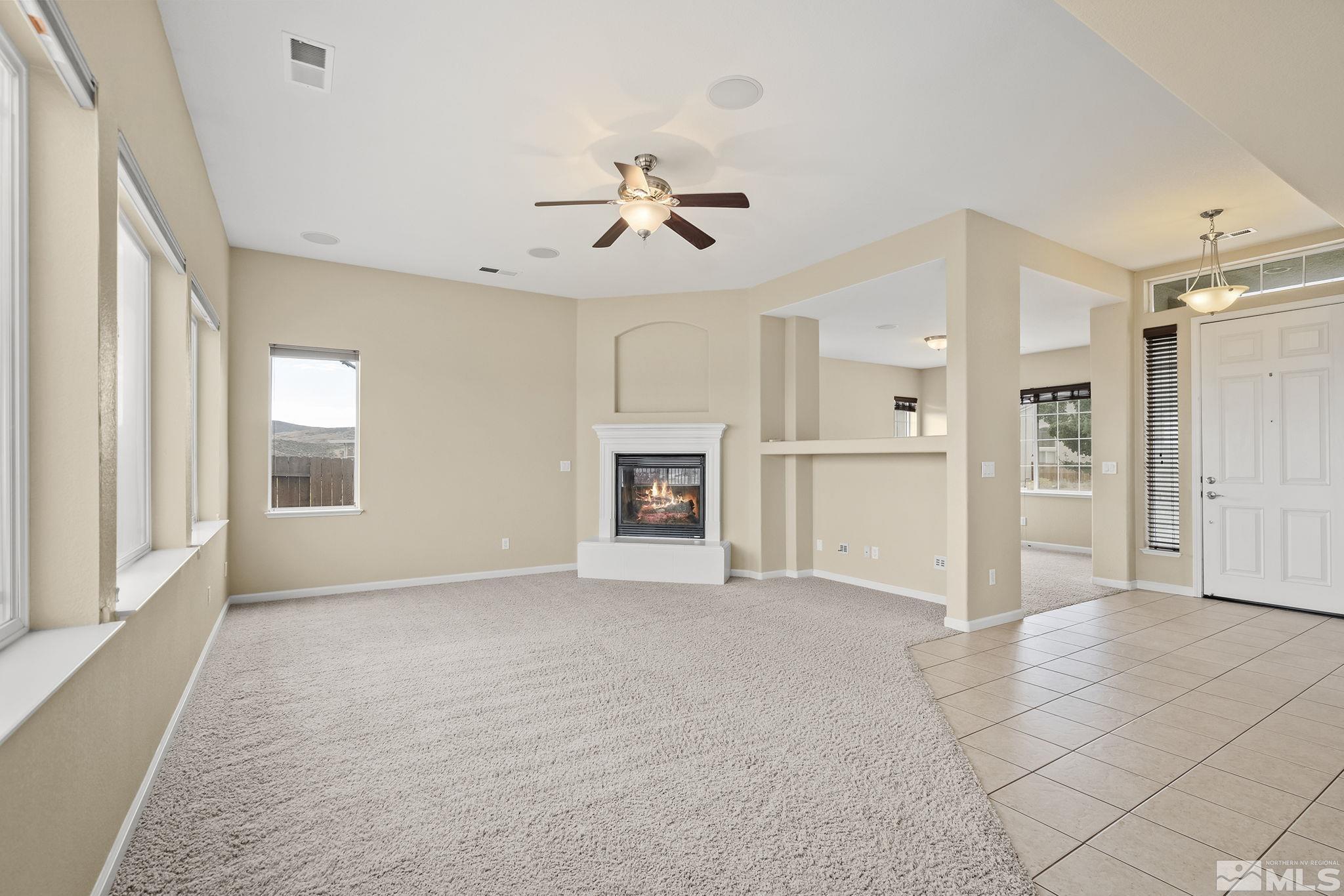 7144 Crest Hill Drive Reno, NV 89506 - Photo 4 of 28 an empty room with windows and a ceiling fan