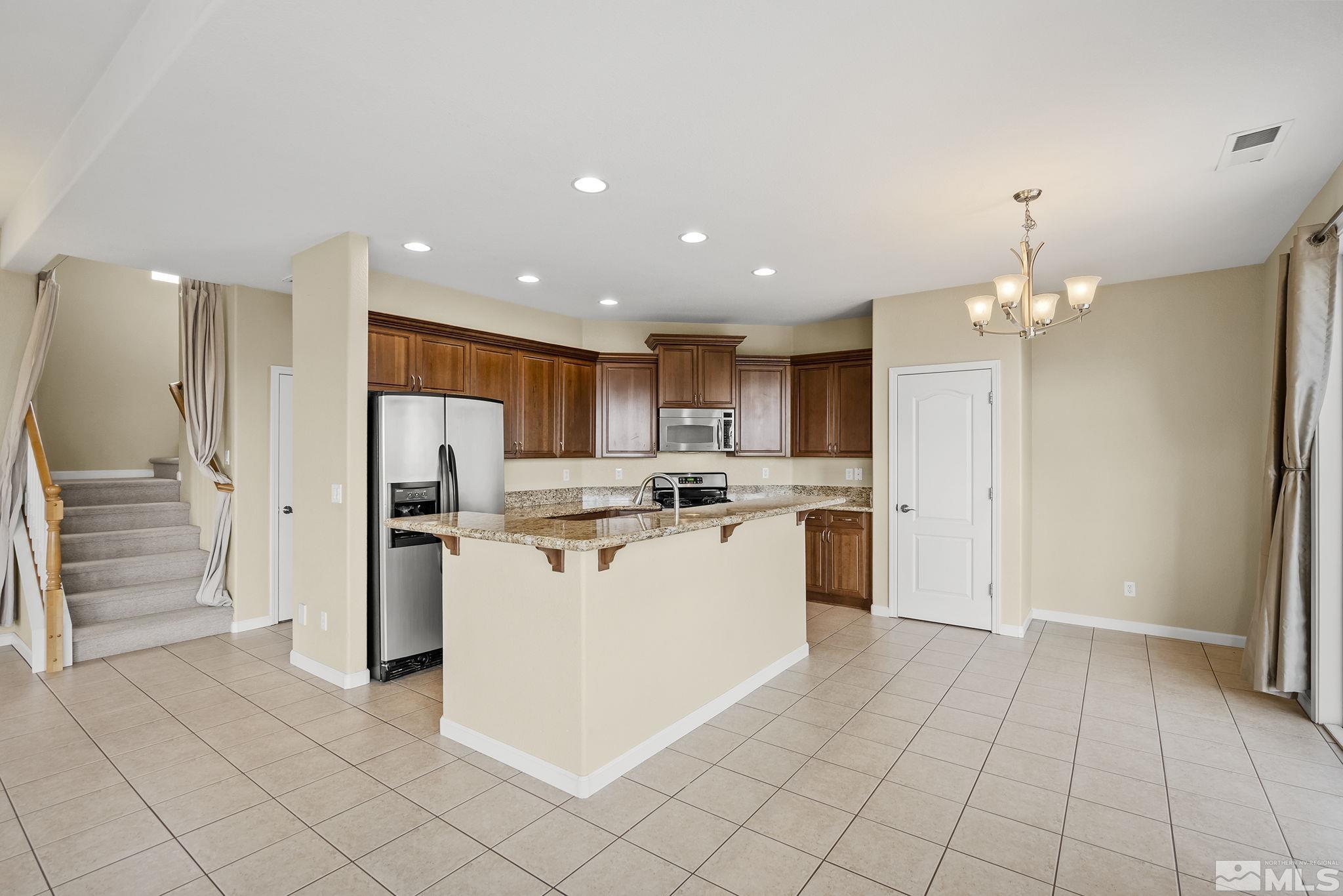 7144 Crest Hill Drive Reno, NV 89506 - Photo 6 of 28 a kitchen with a refrigerator and a stove top oven