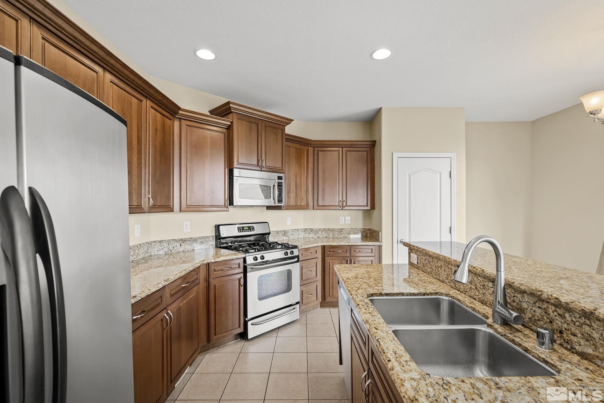 7144 Crest Hill Drive Reno, NV 89506 - Photo 8 of 28 a kitchen with stainless steel appliances granite countertop a sink stove and refrigerator