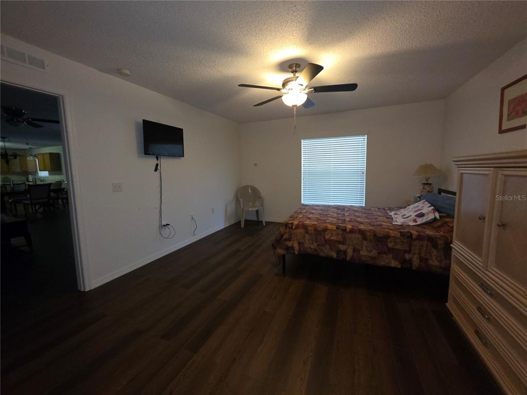 9276 Elm Court Spring Hill, FL 34606 - Photo 11 of 35 a bedroom with a bed and a chandelier