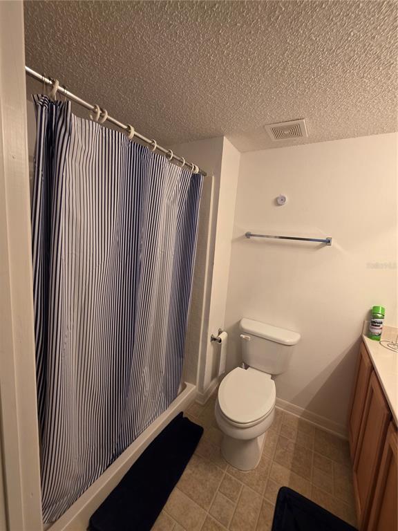 9276 Elm Court Spring Hill, FL 34606 - Photo 13 of 35 a bathroom with a toilet and a shower curtain