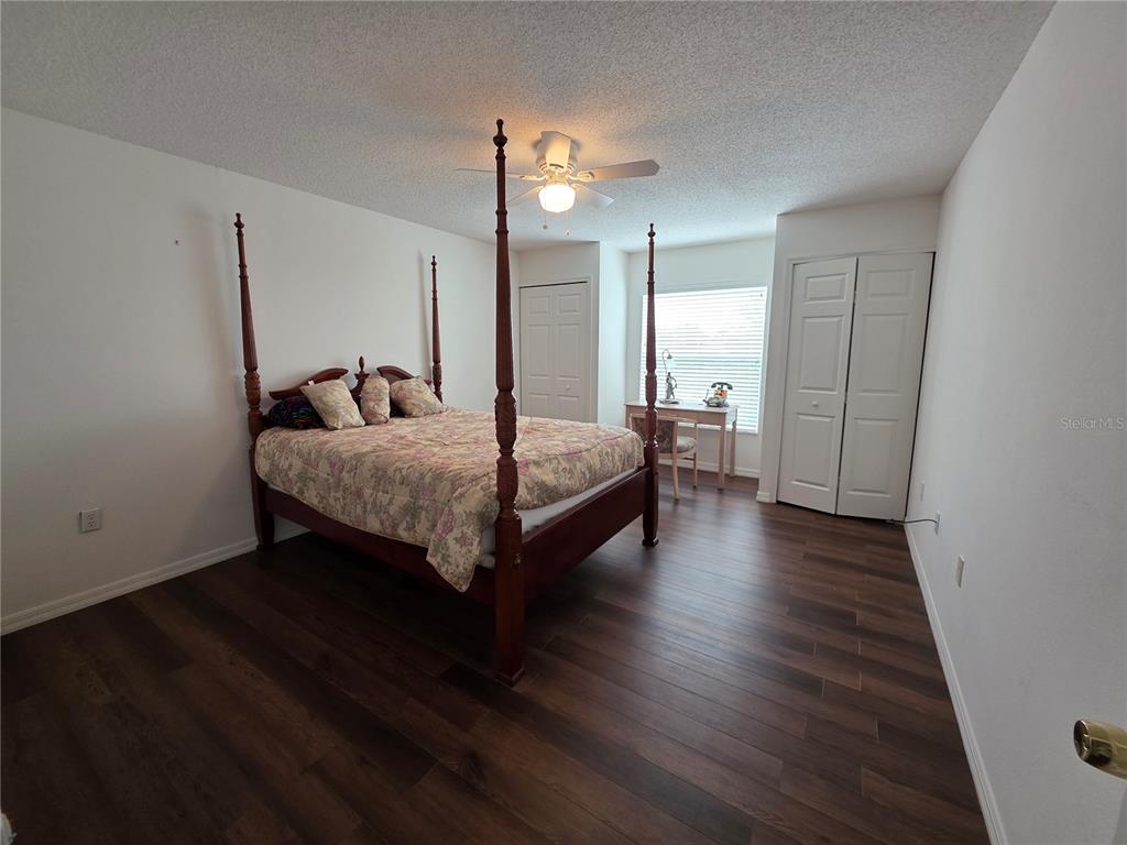 9276 Elm Court Spring Hill, FL 34606 - Photo 16 of 35 a bedroom with a bed and wooden floor
